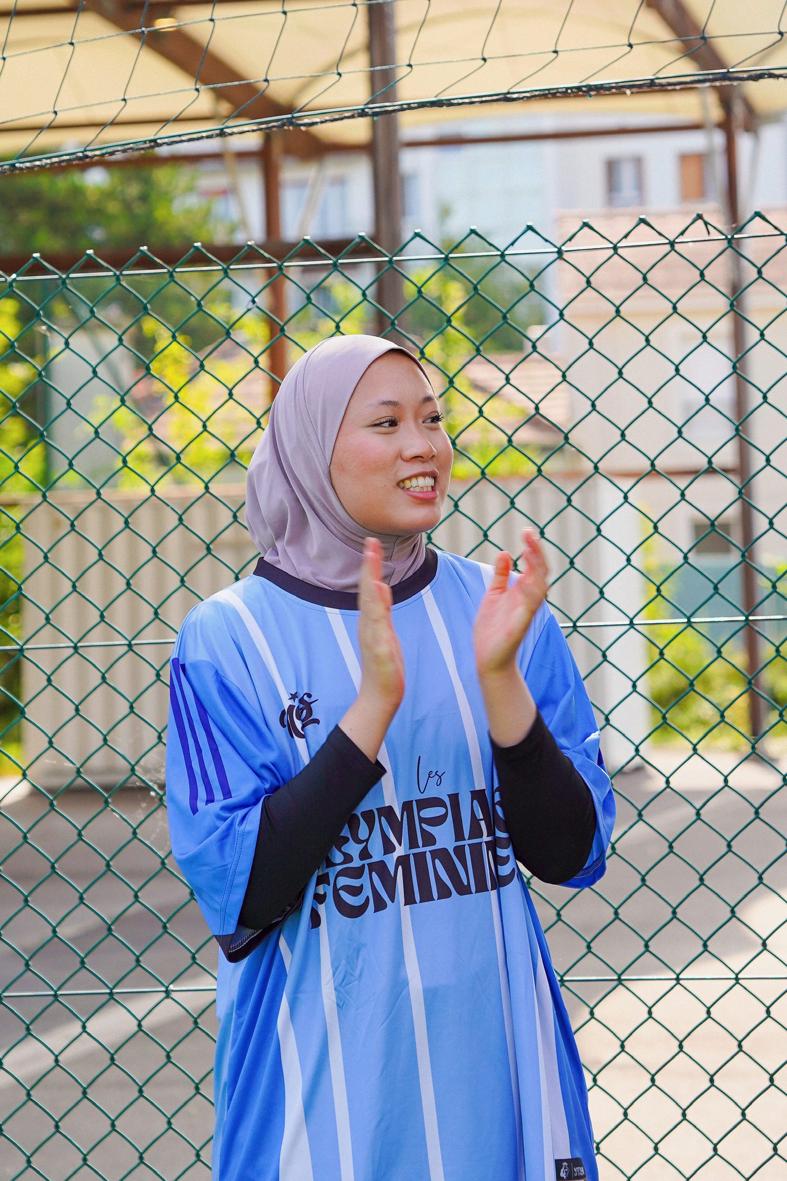 Adhérente souriante applaudissant en maillot des Olympiades Féminines
